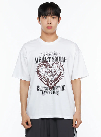 Men's Heart Graphic Tee IL514 White close-up front shot on male model cropped at waist highlighting HEART SMILE grunge graphic print with dark brown brushstroke heart detail
