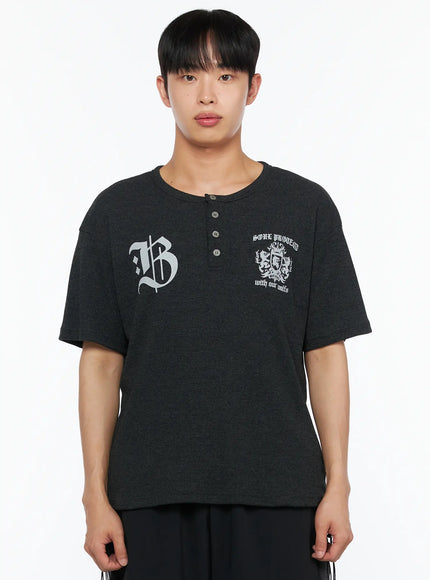 Men's Henley Waffle Tee IL514 Charcoal cropped front shot on male model highlighting gothic B and soul protect crest graphic print with waffle texture