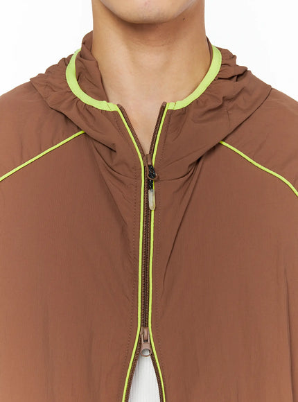Men's Hooded Windbreaker IL528 Brown close-up detail of neon yellow neckline binding, center zip pull, and hood gather on lightweight nylon fabric