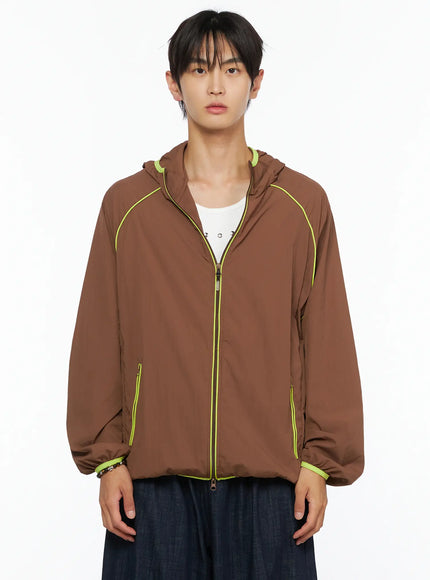 Men's Hooded Windbreaker IL528 Brown front close-up on model, open zip showing neon yellow center-front piping and neon hood binding detail