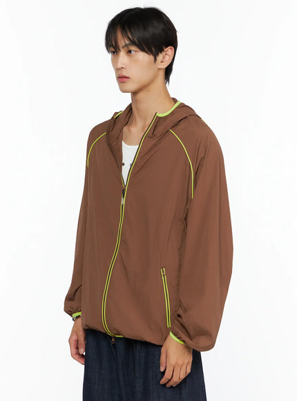 Men's Hooded Windbreaker IL528 Brown side shot on model, open zip showing layered tee, neon yellow raglan piping and zip pocket detail