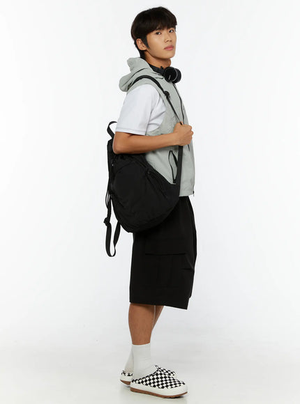 Men's Hooded Zip-Up Vest IL513 Gray side shot on male model holding backpack strap with headphones around neck styled with cargo shorts