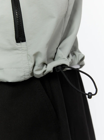 Men's Hooded Zip-Up Vest IL513 Gray side shot on male model pulling up hood with both hands showing side zip pocket and armhole
