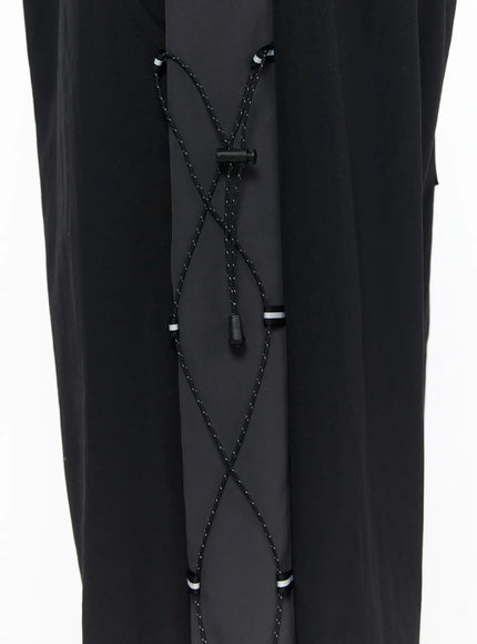 Men's Lace-Up Track Pants (Black) IL514 Black close-up detail of upper thigh lace-up cross-cord panel with cord lock toggle and reflective striped stoppers