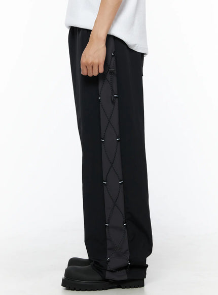 Men's Lace-Up Track Pants (Black) IL514 Black side-view full-length on model showing entire lace-up cord panel with reflective cord stoppers along outer leg