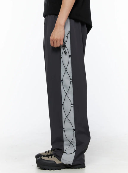 Men's Lace-Up Track Pants (Dark Gray) IL514 dark gray side close-up shot on model highlighting full-length lace-up cord detail and toggle drawstring on side panel