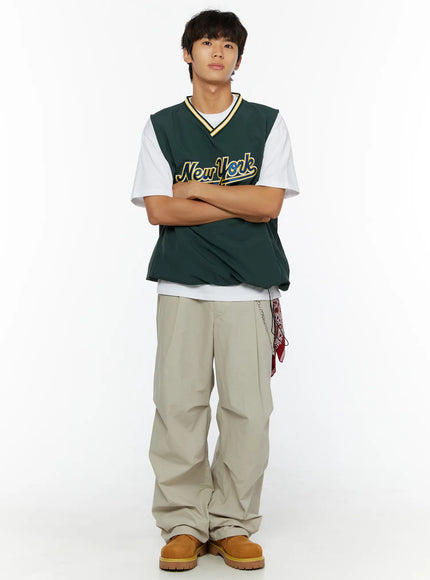 Men's Layered Cross Chain IL509 Silver front full body on male model arms crossed wearing green New York varsity vest white tee beige wide-leg trousers chain visible at hip
