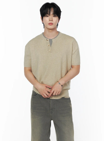 LEWKIN Men's Layered Henley Neck Knit Tee IL502 Beige front shot on male model hands clasped standing pose with gray contrast ribbed collar and gold buttons styled with gray wide-leg jeans