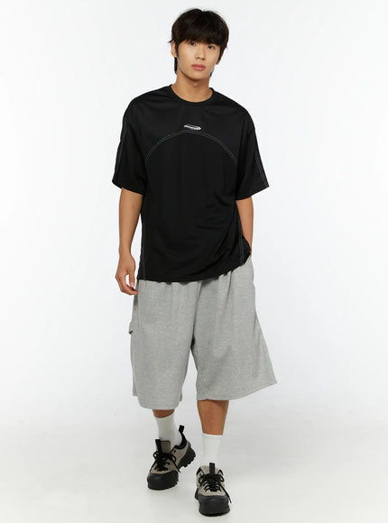 Men's Lettering Bermuda Shorts IL513 Gray full-length front view on male model, wide-leg bermuda silhouette, paired with black graphic tee and chunky sneakers, relaxed streetwear outfit