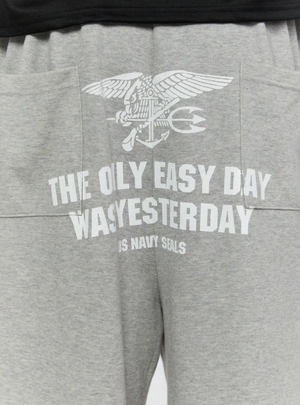 Men's Lettering Bermuda Shorts IL513 Gray close-up detail of back graphic print, white eagle anchor trident US Navy Seals lettering on heather gray cotton terry fabric