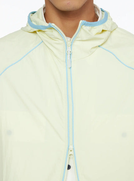 Men's Lightweight Windbreaker IL528 Light yellow close-up detail of center-front zipper and hood with blue contrast piping trim