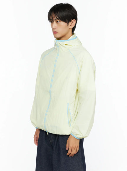 Men's Lightweight Windbreaker IL528 Light yellow side view on model showing blue contrast piping seams and zip side pocket detail