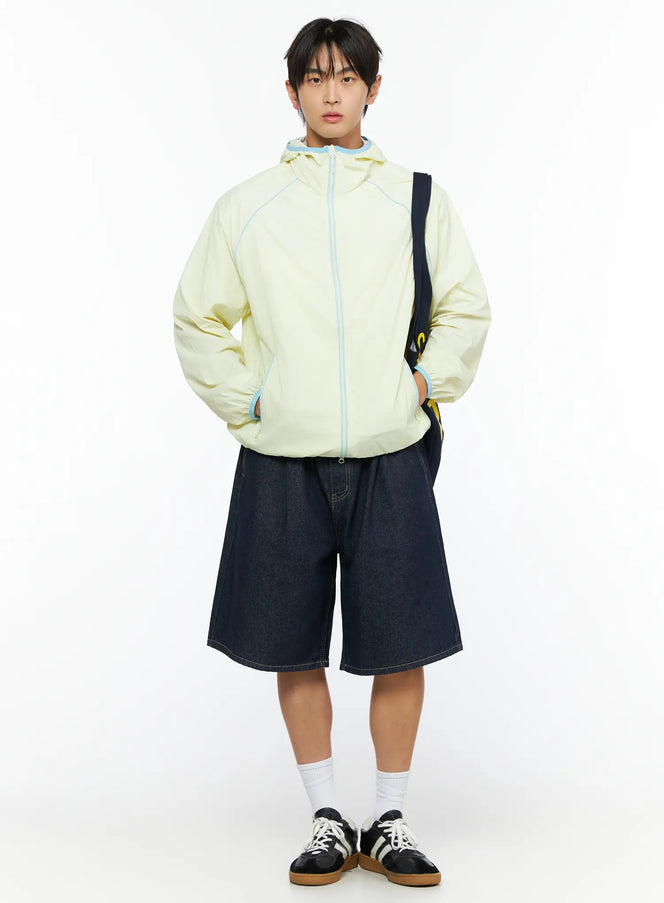 Men's Lightweight Windbreaker IL528 Light yellow front full-body on model styled with denim shorts, crossbody bag, and sneakers