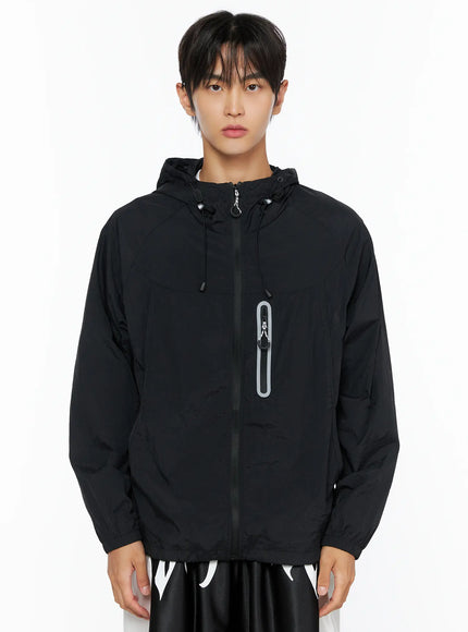Men's Lightweight Windbreaker Jacket IL515 Black cropped front shot on male model showing zip placket reflective chest pocket and adjustable hood drawcord