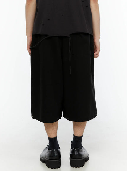 Men's Logo Embroidered Snap Hem Bermuda Sweat Shorts (Black) IL507 back view on model showing plain rear panel elastic drawstring waist and metal snap hem details