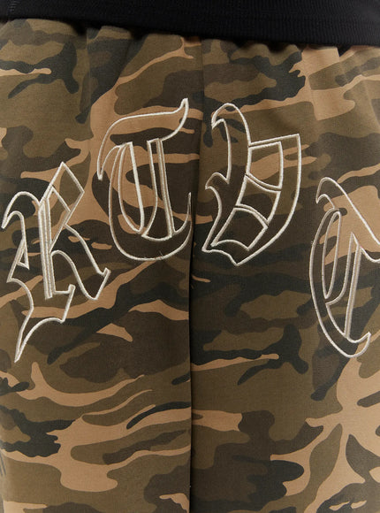 Men's Logo Embroidered Snap Hem Bermuda Sweat Shorts (Camouflage) IL507 Camouflage side view on model standing straight, wide-leg hem drape visible, partial embroidery on left thigh, snap hem detail at leg opening