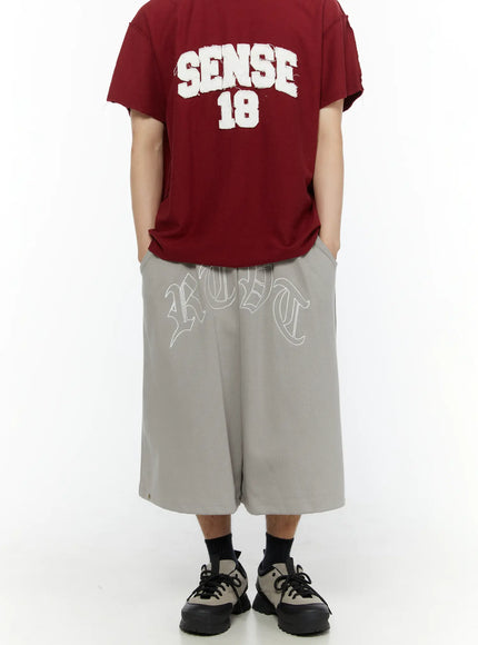 Men's Logo Embroidered Snap Hem Bermuda Sweat Shorts (Gray) IL507 gray back view on model full-length styled with burgundy graphic tee and chunky sneakers