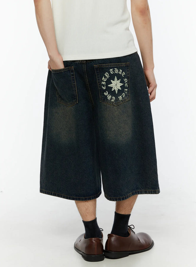 Men's 'Never Stop' Graphic Bermuda Jorts (Dark Blue) IL507 back close-up on model showing star compass graphic and circular old English text on rear pocket