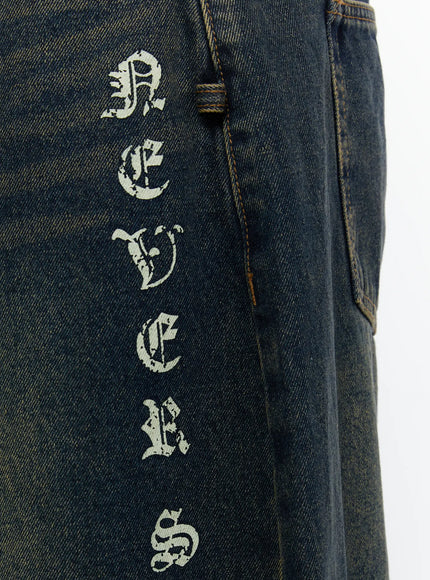 Men's 'Never Stop' Graphic Bermuda Jorts (Dark Blue) IL507 close-up detail of vertical old English distressed letter graphic print on front leg panel