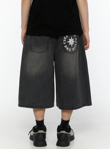Men's 'Never Stop' Graphic Bermuda Jorts (Dark Gray) IL507 back view on model showing wide-leg hem washed denim and star circular graphic on right back pocket