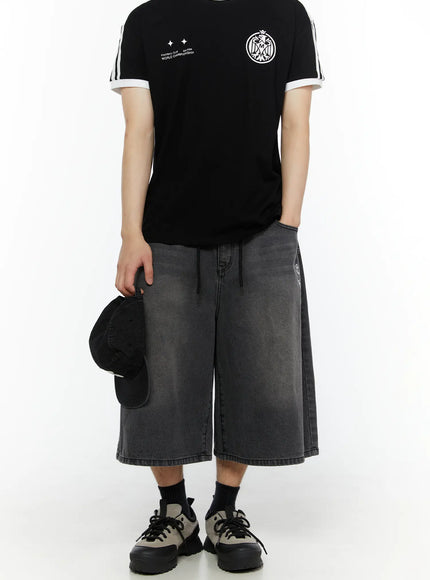 Men's 'Never Stop' Graphic Bermuda Jorts (Dark Gray) IL507 back full view on model styled with black graphic tee holding cap at side