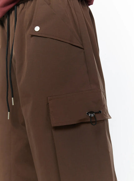 Men's Nylon Cargo Drawstring Bermuda Shorts (Dark Brown) IL507 Dark brown close-up detail of left side showing snap front pocket flap, cargo pocket, and black drawstring waistband