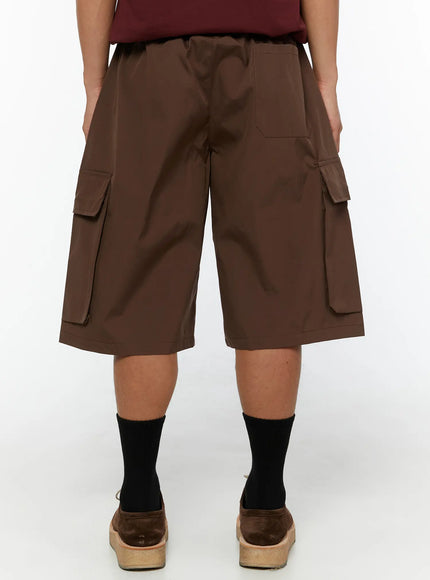 Men's Nylon Cargo Drawstring Bermuda Shorts (Dark Brown) IL507 Dark brown back view on model showing rear cargo pockets and smooth nylon fabric with elasticated waistband