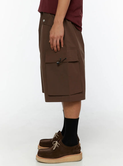 Men's Nylon Cargo Drawstring Bermuda Shorts (Dark Brown) IL507 Dark brown side view on model showing right cargo pocket toggle detail and elasticated drawstring waistband