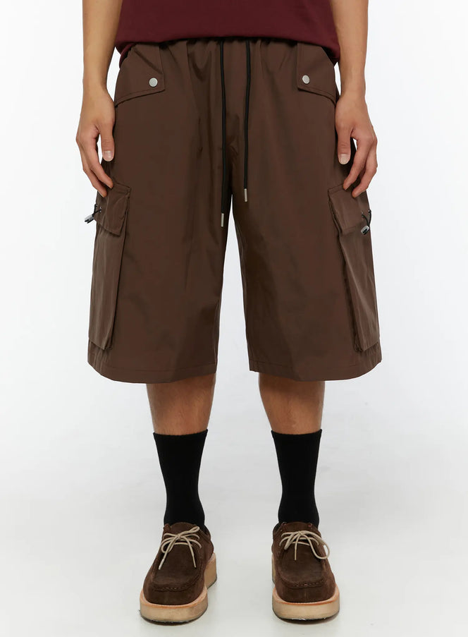 LEWKIN Men's Nylon Cargo Drawstring Bermuda Shorts (Dark Brown) IL507 Dark brown front close-up on model showing snap pockets and side cargo pockets with toggle closures