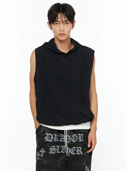 Men's Nylon Hooded Vest IL520 Black front half-body shot on male model hands at sides, snap button hood detail, layered over white inner top
