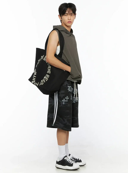 Men's Nylon Hooded Vest IL520 Dark green side full-body shot on male model carrying black tote bag, showing side profile and relaxed fit