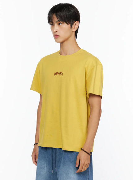 Men's Osaka Graphic T-Shirt IL520 Yellow side shot on model showing left profile, red OSAKA arch embroidery on chest, oversized cotton fabric detail