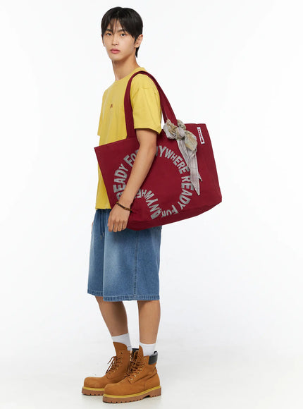 Men's Osaka Graphic T-Shirt IL520 Yellow side shot on model carrying burgundy tote on shoulder, showing relaxed sleeve and hem length with denim shorts