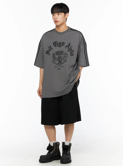 Men's Oversized Athletic Tee IL514 Gray full-body front shot on male model styled with black wide shorts and boots, oversized silhouette with tonal crest graphic