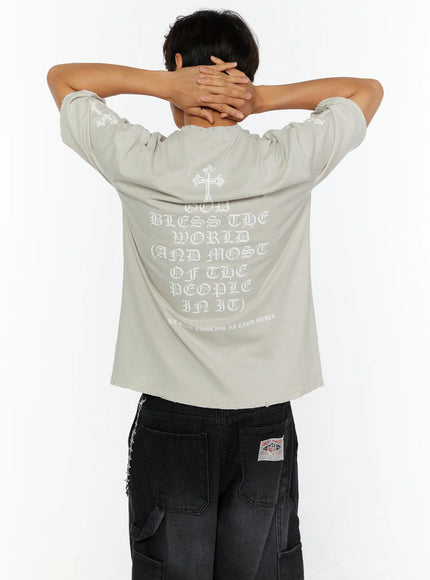 Men's Oversized Graphic T-Shirt IL513 back model shot showing gothic old English text God Bless The World print and cross graphic on beige colorway