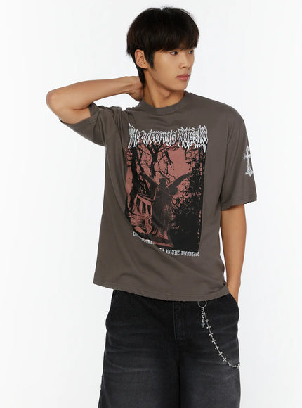 Men's Oversized Graphic T-Shirt IL513 charcoal gray front model shot with hand on neck showing red-toned angel statue graphic and white cross sleeve print