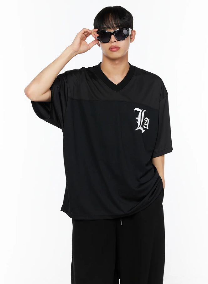 LEWKIN Men's Oversized Mesh Rugby Tee IL514 Black front shot on male model wearing sunglasses, V-neck with panel seam, white La gothic logo, paired with black pants