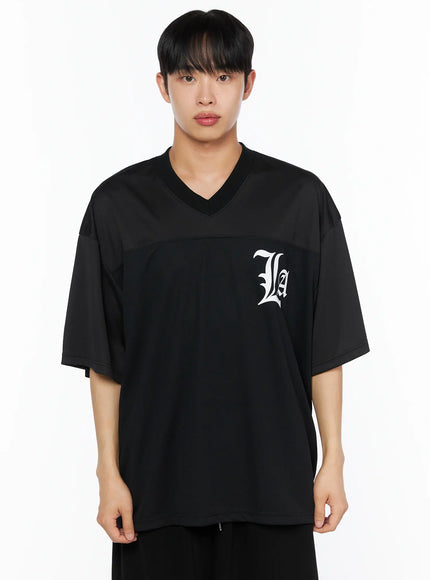 Men's Oversized Mesh Rugby Tee IL514 Black front close-up bust shot on male model, white old-english La gothic logo on chest, contrast mesh panel at upper front, V-neck