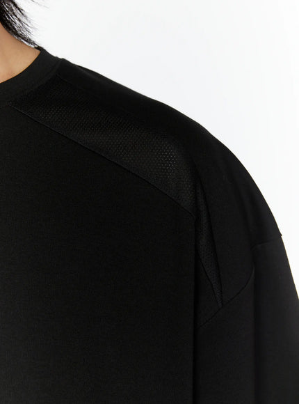 Men's Oversized Mesh Tee (Black) IL509 close-up detail of perforated mesh shoulder panel and raglan seam construction on model