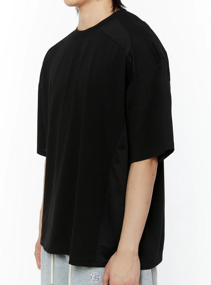 Men's Oversized Mesh Tee (Black) IL509 side view on male model showing mesh side panel insert and dropped shoulder boxy cut with gray shorts