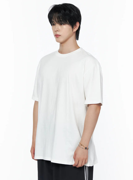 Men's Oversized Studded Tee IL502 White side shot on male model three-quarter angle showing dropped shoulder and relaxed cotton silhouette with bracelet