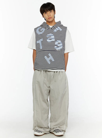 Men's Oversized Sweatpants IL510 Light gray front view on male model with hands in pockets, full-length styling with striped vest and checkered sneakers