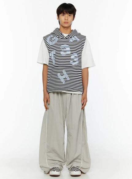 Men's Oversized Sweatpants IL510 Light gray full-body front view on male model standing straight, wide-leg nylon trousers with white side piping and drawstring hem