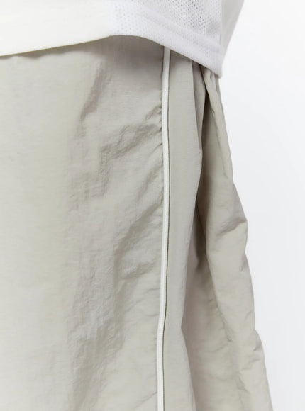 Men's Oversized Sweatpants IL510 Light gray close-up detail of hip area showing white side piping seam and crinkled nylon texture against waistband