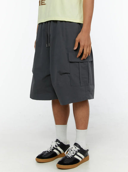 Men's Parachute Cargo Shorts IL515 Dark gray angled side shot on male model highlighting right cargo pocket detail and relaxed wide-leg silhouette