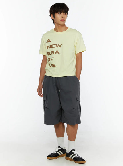 Men's Parachute Cargo Shorts IL515 Dark gray full-body angled shot on male model looking sideways, styled with yellow tee and white crew socks