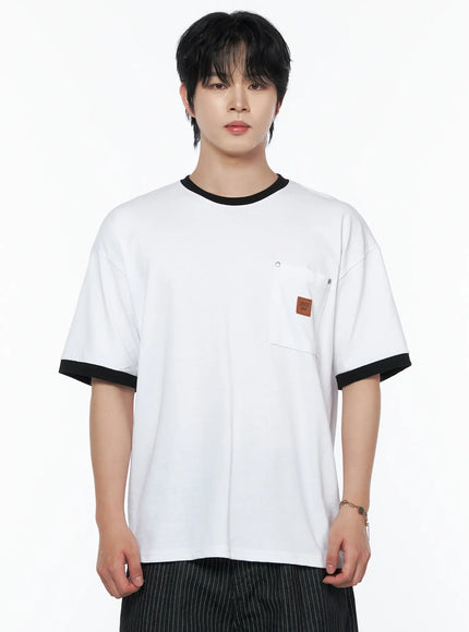 Men's Patch Detail Short Sleeve Tee IU523 White close-up front view on male model, black ringer crewneck collar and sleeve cuffs, chest pocket with leather brand patch and metal pin detail