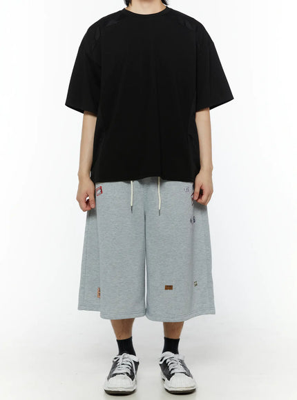 Men's Patch Detail Shorts (Gray) IL509 gray front full-body shot on male model wearing black oversized tee hands at sides wide-leg silhouette visible