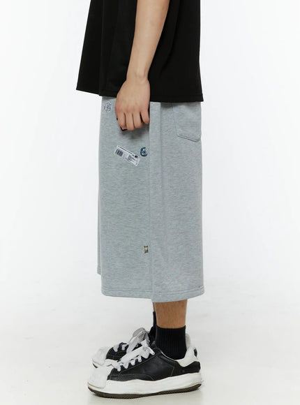 Men's Patch Detail Shorts (Gray) IL509 gray side shot on male model showing back pocket detail barcode patch and wide-leg silhouette with drawstring waist