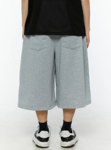 Men's Patch Detail Shorts (Gray) IL509 gray back view on male model showing two back pockets wide-leg cut and clean rear panel in heathered cotton fleece